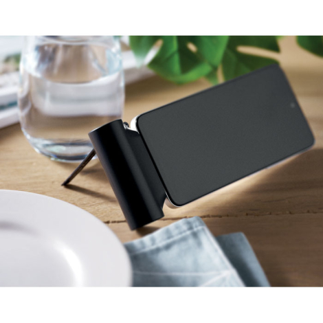Powerbank utilisée comme support pour smartphone posé sur une surface en bois, sans marquage visible.