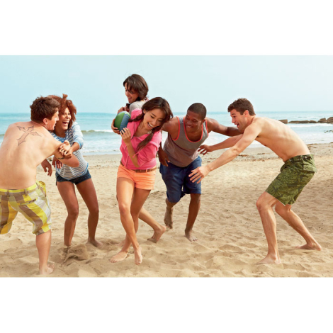 Ballon de rugby utilisé par un groupe de personnes jouant sur la plage, sans marquage discernable.