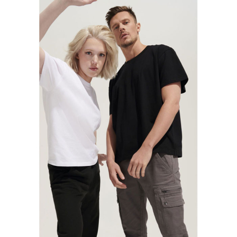 T-shirt oversize unisexe porté en situation lifestyle par un mannequin femme en blanc et un mannequin homme en noir, aucun marqu