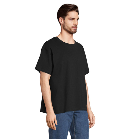 T-shirt oversize unisexe noir porté de trois-quarts par un mannequin homme, sans marquage visible.