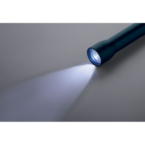 Lampe torche allumée projetant un faisceau lumineux vers l’avant, aucun marquage apparent.