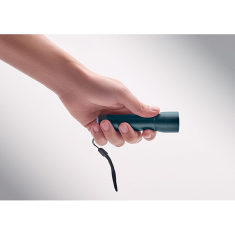 Lampe torche tenue en main en situation d’utilisation, sans personnalisation visible.