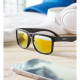 Lunettes de soleil noires avec verres miroirs dorés posées sur une surface en bois avec casque et smartphone en arrière-plan, ma Lunettes de soleil noires avec verres miroirs dorés posées sur une surface en bois avec casque et smartphone en arrière-plan, ma