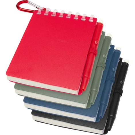 Pile de mini carnets en rouge, vert, bleu et noir avec stylo assorti et mousqueton, sans personnalisation visible.