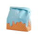 Lunchbag isotherme aux motifs cornet de glace avec partie supérieure bleu clair et base orange texturée présenté fermé sur fond 