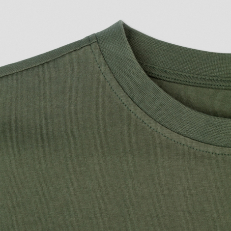 Gros plan sur le col rond d’un T-shirt vert montrant la finition et les coutures, aucune personnalisation visible.