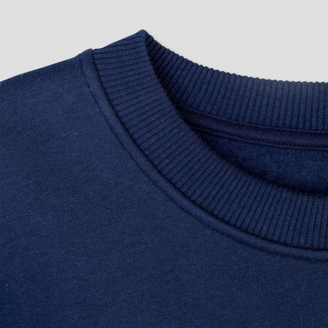 Gros plan sur le col rond d’un sweat-shirt bleu marine montrant la texture du molleton et la finition côtelée, sans marquage app