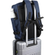 Vue arrière d’un sac cabine bleu fixé sur la poignée télescopique d’une valise, montrant les bretelles et le panneau dorsal, san