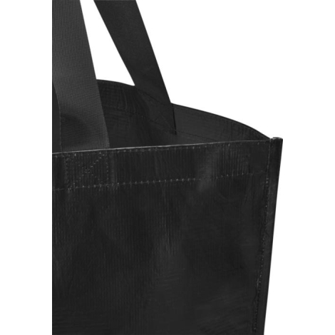 Gros plan sur le bord supérieur d’un cabas noir montrant les anses fixées au sac, sans personnalisation apparente.