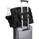 Sac de voyage noir fixé sur la poignée télescopique d’une valise, vue arrière avec poche latérale contenant une gourde, sans per