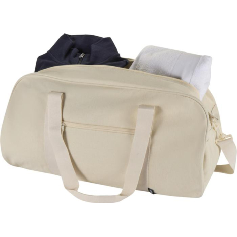 Sac week-end beige partiellement ouvert montrant des vêtements rangés dans le compartiment principal, sans personnalisation visi