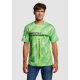 Homme portant un t-shirt vert avec motifs géométriques et texte sur la poitrine et en vertical, sans personnalisation visible