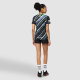 Femme vue de dos portant un t-shirt, avec un décor imprimé de lignes diagonales couvrant l’ensemble du dos. Femme vue de dos portant un t-shirt, avec un décor imprimé de lignes diagonales couvrant l’ensemble du dos.