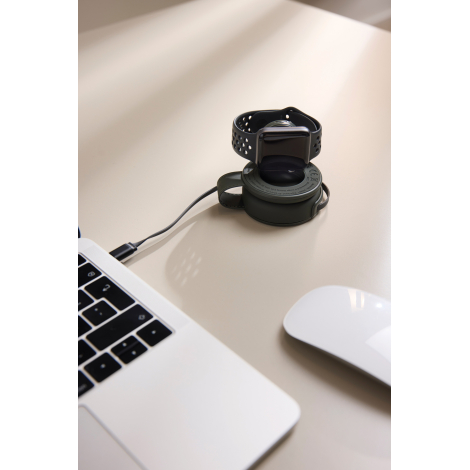 Chargeur utilisé sur un bureau avec montre connectée en cours de recharge en situation d’usage, sans marquage visible