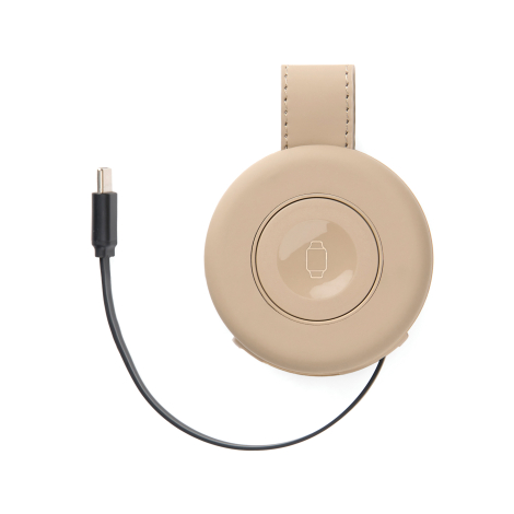 Chargeur beige avec câble USB-C branché et pictogramme visible sur la surface de charge, sans personnalisation apparente