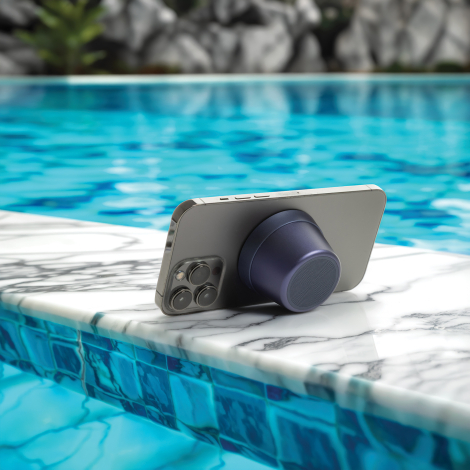 Haut-parleur fixé à l’arrière d’un smartphone au bord d’une piscine en extérieur, sans marquage visible