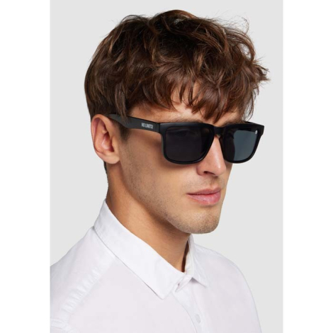 Homme portant des lunettes avec monture noire avec marquage discret visible sur les branches