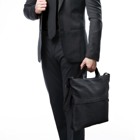 Sac noir tenue dans une main 