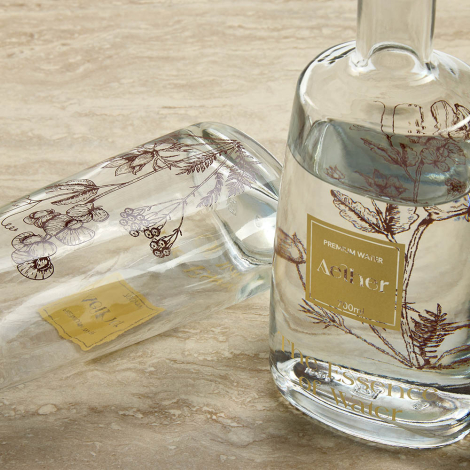 Deux bouteilles en verre avec liquide dont une couchée avec marquage visible sur la surface extérieure.