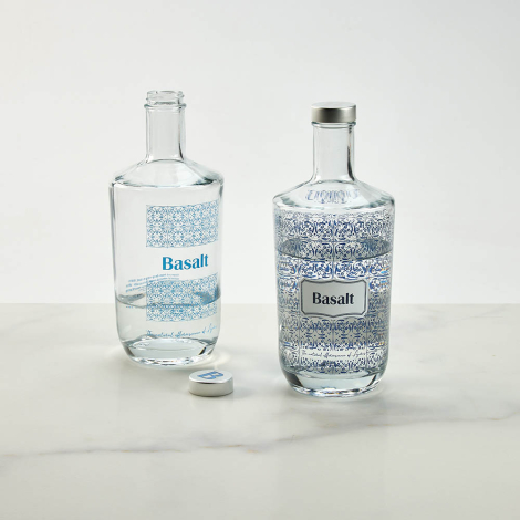 Deux bouteilles en verre contenant du liquide posées sur une surface avec marquage visible sur la surface extérieure.