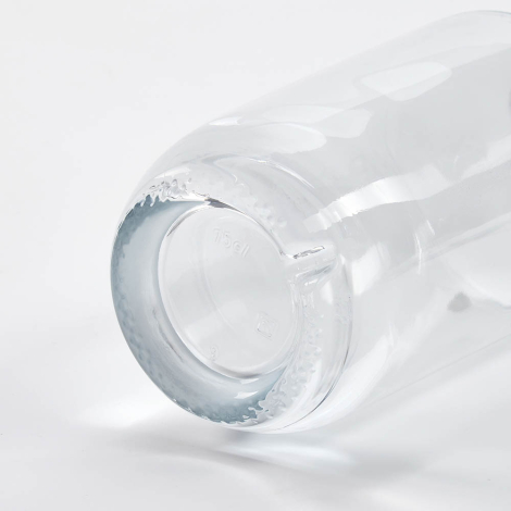 Gros plan du fond d’une bouteille en verre couchée mettant en avant la base, sans personnalisation visible.