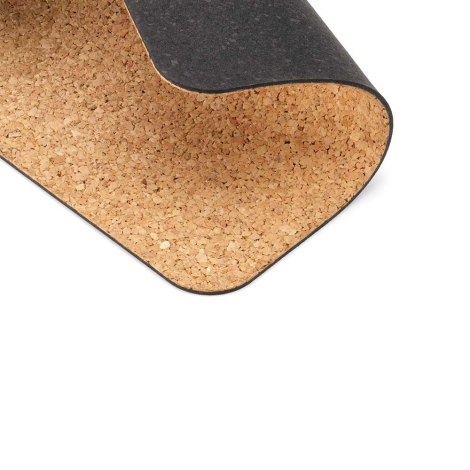 Gros plan d’un tapis de souris en liège avec un coin relevé montrant la surface en liège et le dessous foncé, sans marquage visi