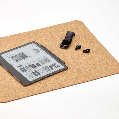Sous-main en liège utilisé sur un bureau avec une liseuse, une montre et des écouteurs posés dessus, sans personnalisation visib