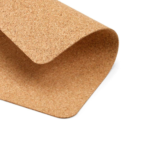 Gros plan d’un sous-main en liège avec un coin relevé montrant la souplesse du matériau, sans marquage visible.