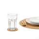 Sous-verre en liège utilisé sous un verre sur une table dressée avec assiette et couverts, sans personnalisation visible.
