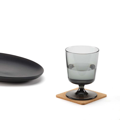 Sous-verre carré en liège utilisé sous un verre avec une assiette à proximité, sans personnalisation visible.