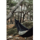Hamac noir suspendu à un arbre en forêt, avec une personne allongée, sans marquage visible sur le produit.