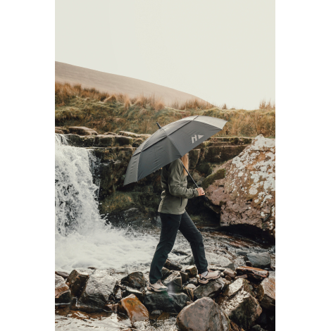 Personne marchant en extérieur avec parapluie ouvert au-dessus de la tête, sans personnalisation visible sur la toile.