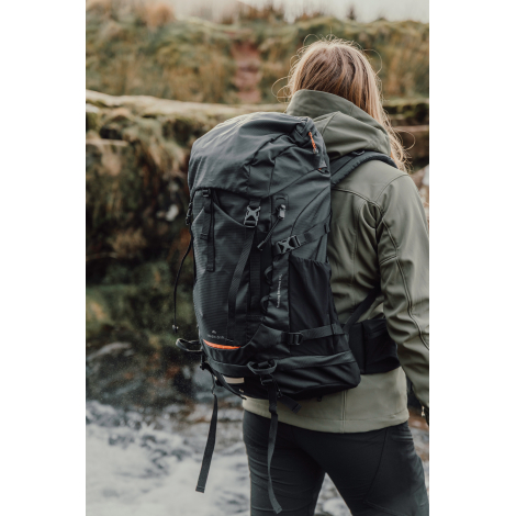 Sac à dos porté par une personne en extérieur vu de dos, sans personnalisation visible.