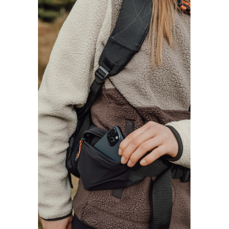 Gros plan sur une poche portée à la taille contenant un objet, sans personnalisation visible.