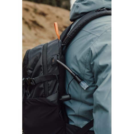 Gros plan sur le côté du sac porté avec tube d’hydratation, sans marquage visible.