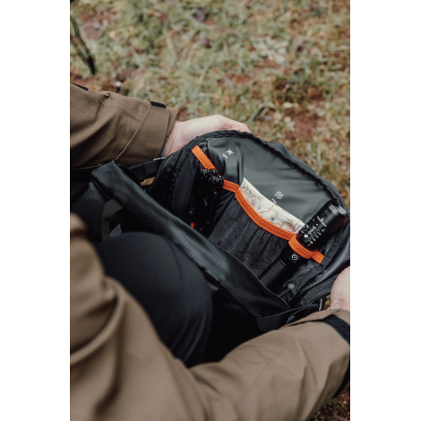 Sac ouvert tenu par une personne montrant les compartiments internes, sans personnalisation visible.