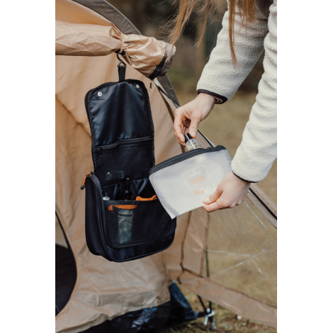 Personne manipulant la trousse ouverte en extérieur, sans personnalisation visible.