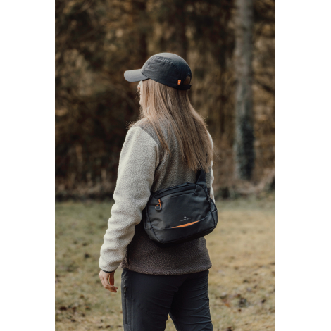 Personne portant le sac bandoulière de profil en extérieur, sans personnalisation visible.