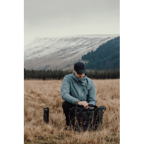 Personne utilisant un sac isotherme en extérieur, sans marquage visible.