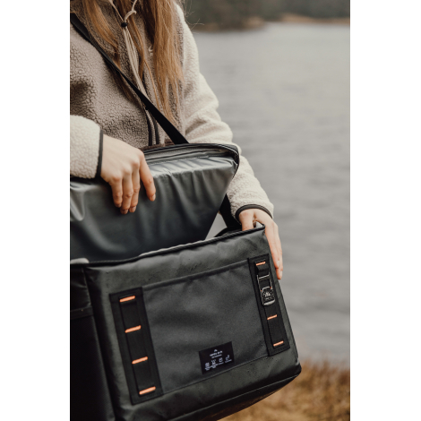 Sac isotherme manipulé par une personne avec ouverture du compartiment supérieur, sans personnalisation visible.