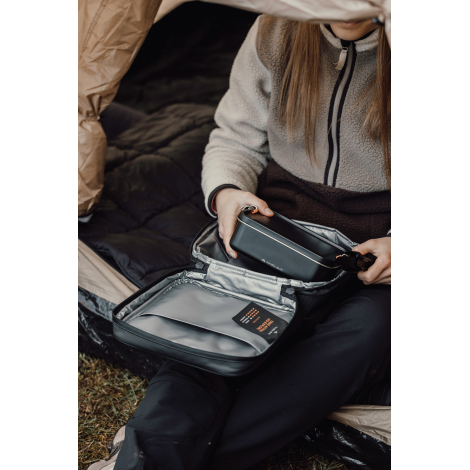 Sac isotherme ouvert tenu par une personne montrant les compartiments internes, sans marquage visible.