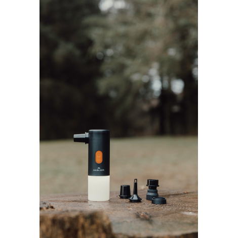 Lampe de camping posée en extérieur avec accessoires et embout fixé, sans marquage visible.