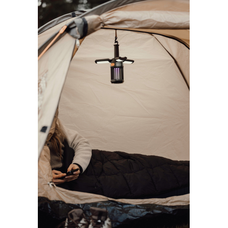 Lampe de camping suspendue dans une tente avec éclairage actif, sans marquage visible.