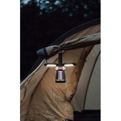 Lampe de camping suspendue à une tente en extérieur avec éclairage actif, sans marquage visible.