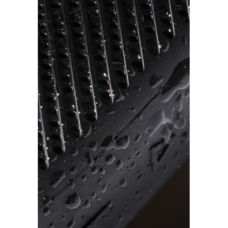 Gros plan sur surface texturée avec gouttes d’eau sur enceinte, sans personnalisation visible.