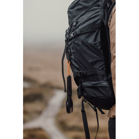 Set de couverts accroché à un sac à dos via la dragonne, sans marquage visible.