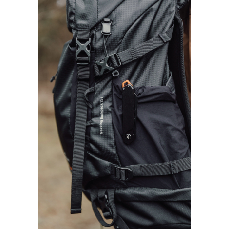 Couteau pliant fixé à un sac à dos via clip, sans personnalisation apparente.