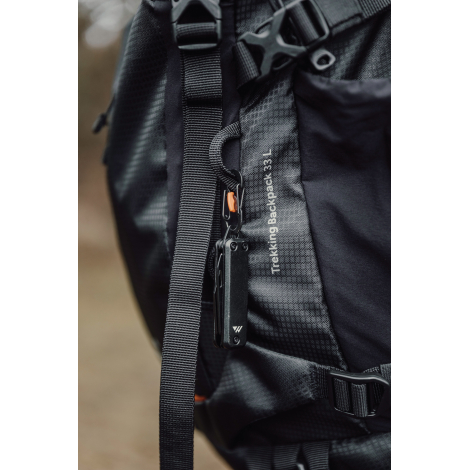 Porte-clés multifonctions accroché à un sac à dos via mousqueton, sans personnalisation visible.