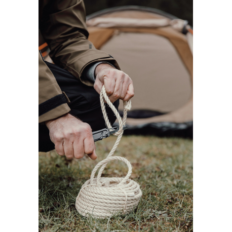Outil multifonctions utilisé pour couper une corde en extérieur, sans personnalisation apparente.