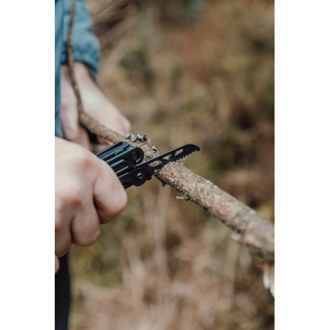 Pince multifonctions utilisée pour couper une branche avec scie intégrée, sans personnalisation visible.